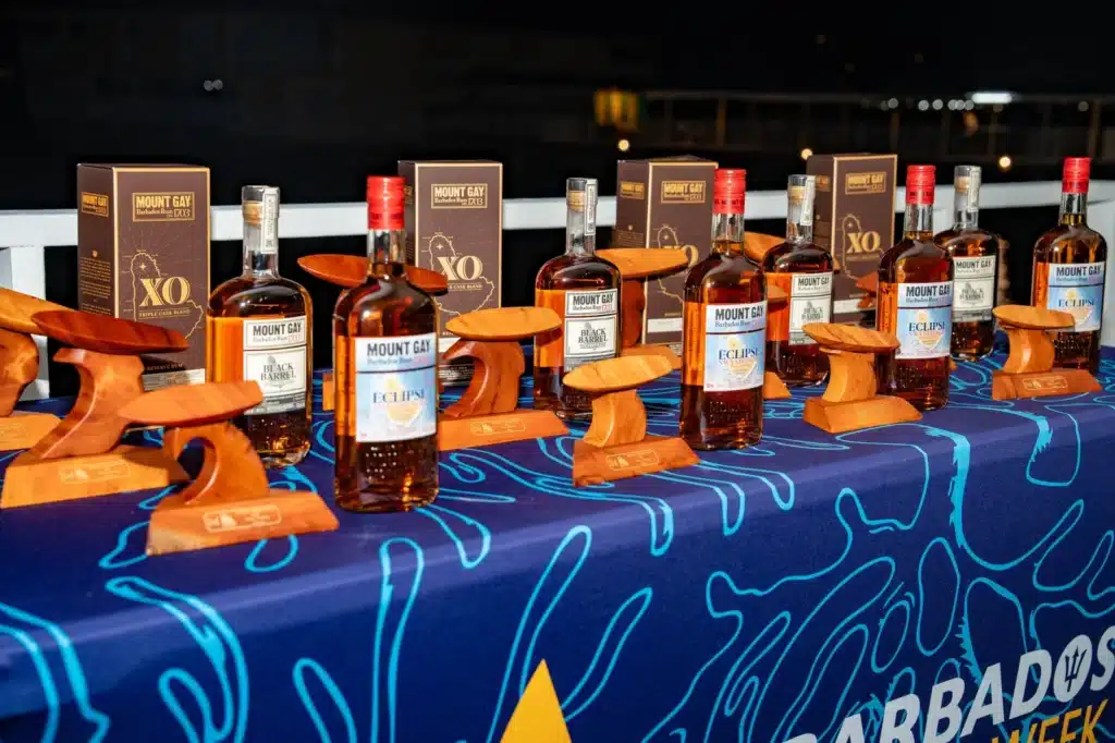 Wooden Barbados Sailing Week trophies lined up with bottles of Mount Gay XO, Black Barrel and Eclipse Navy Strength.