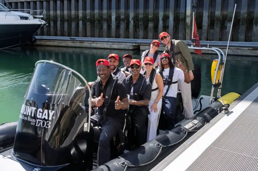 Guests in Mount Gay Red Caps and life jackets aboard a Mount Gay branded RIB in the Cowes marina.